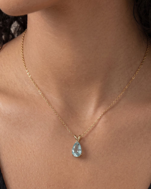 Collier Azur Bellurr porté, pendentif goutte bleu ciel sur chaîne fine dorée