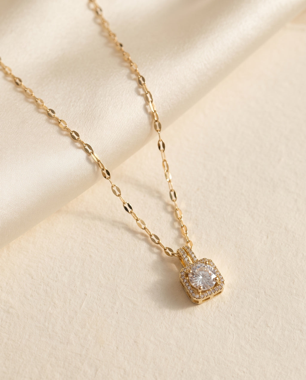 Collier Lumière Bellurr posé sur papier crème et satin ivoire