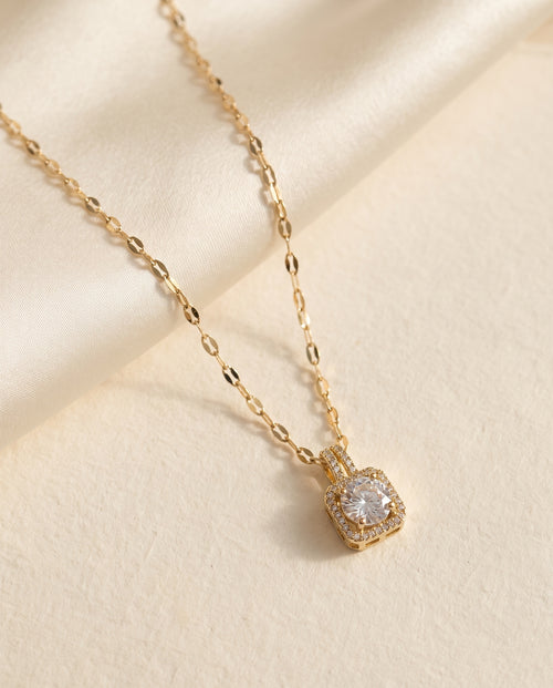 Collier Lumière Bellurr posé sur papier crème et satin ivoire