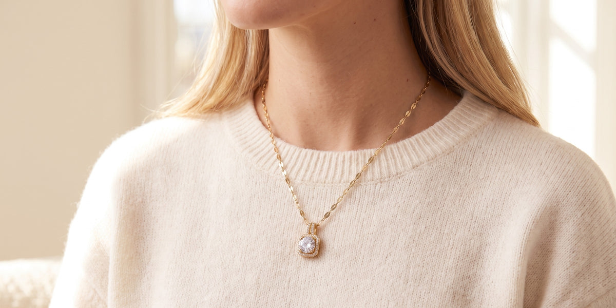 Femme portant le collier Lumière Bellurr sur un pull ivoire, lumière du matin
